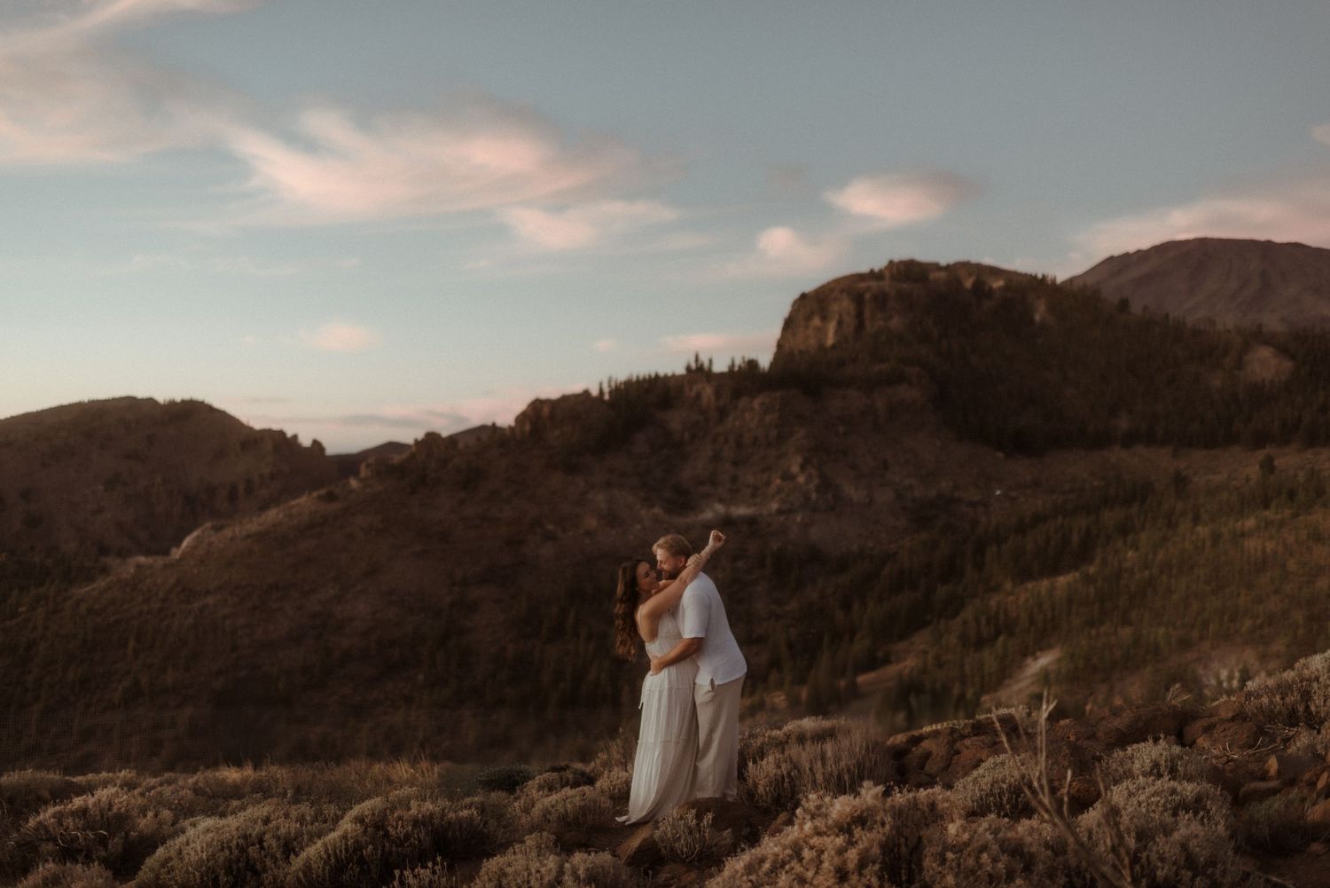 Romantic mountain portrait with couple silhouetted against sunset sky. Tenerife Wedding Photographer at Teide.