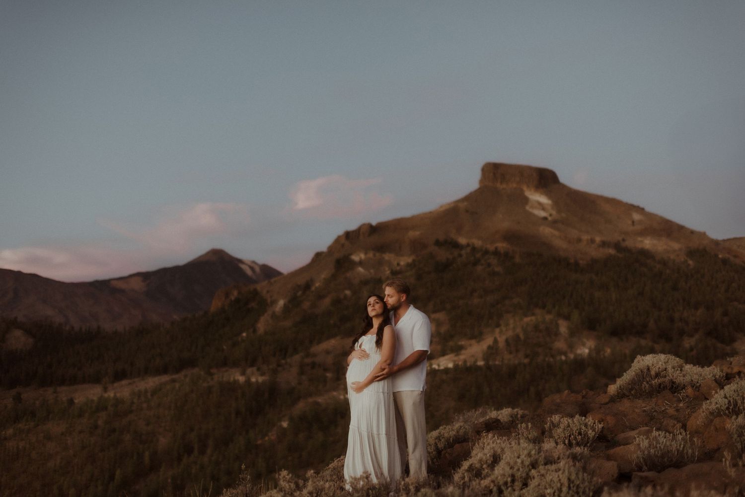 A romantic sunset engagement photo against dramatic mountain peaks in golden light. Tenerife Wedding Photographer at Teide.