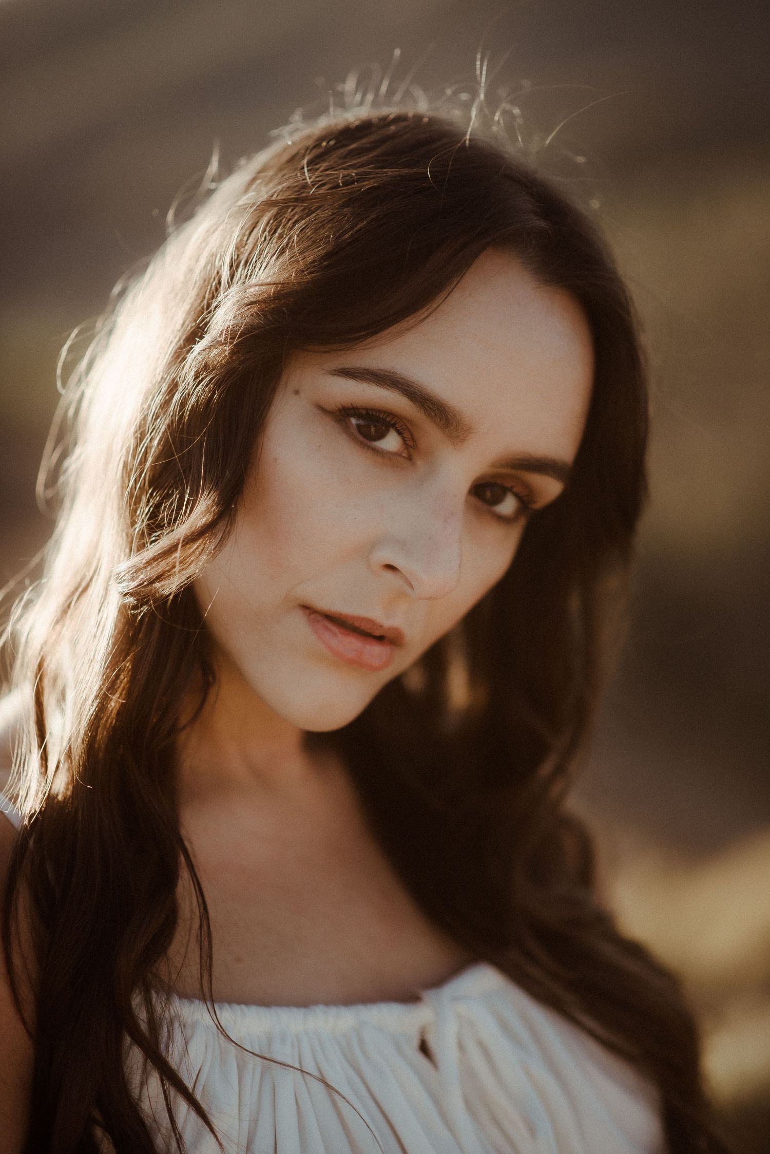 Soft sun-lit portrait with backlit hair and white dress in natural outdoor setting. Tenerife Wedding Photographer at Teide.