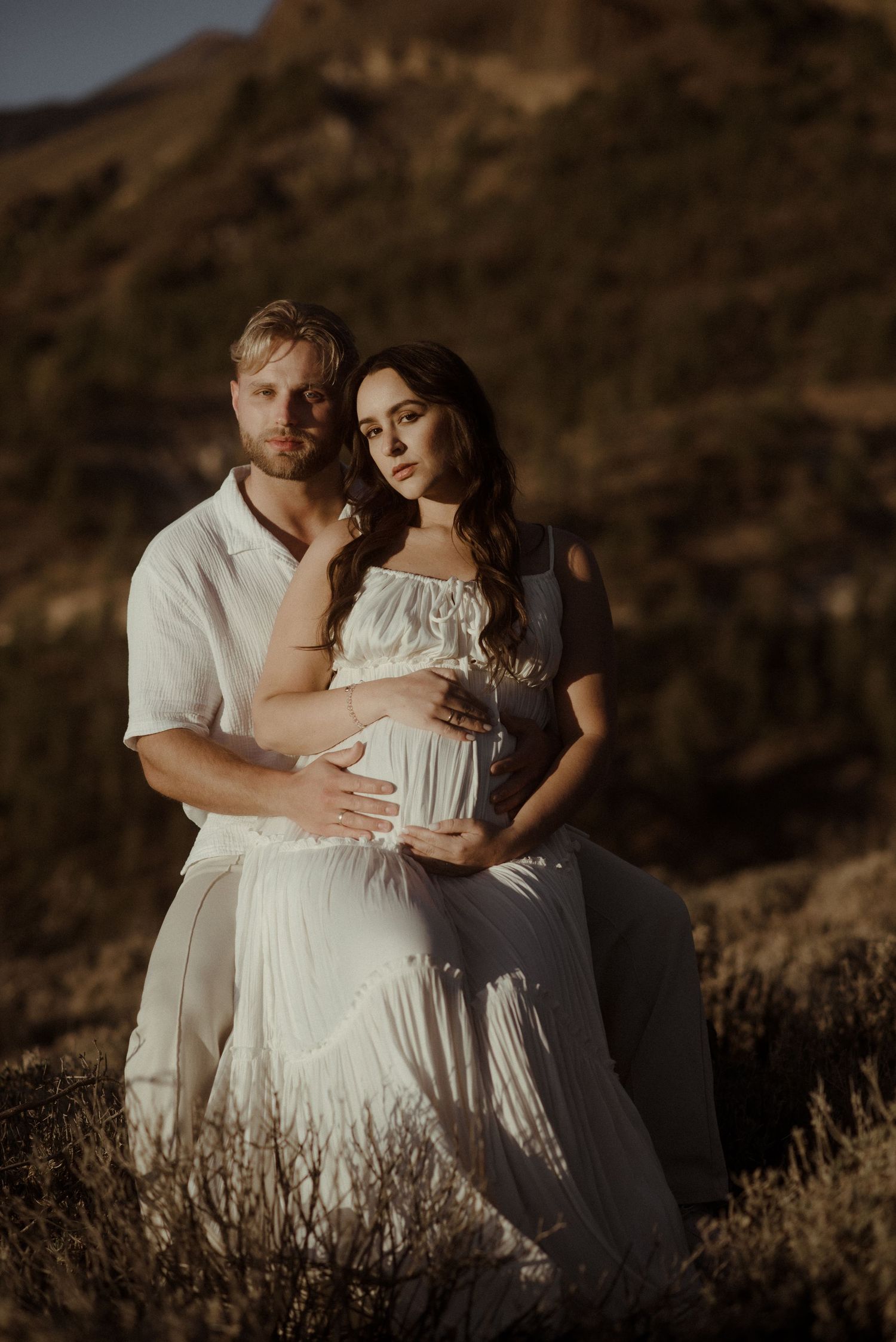 Romantic sunset portrait of couple in white clothing against mountainous backdrop. Tenerife Wedding Photographer at Teide.