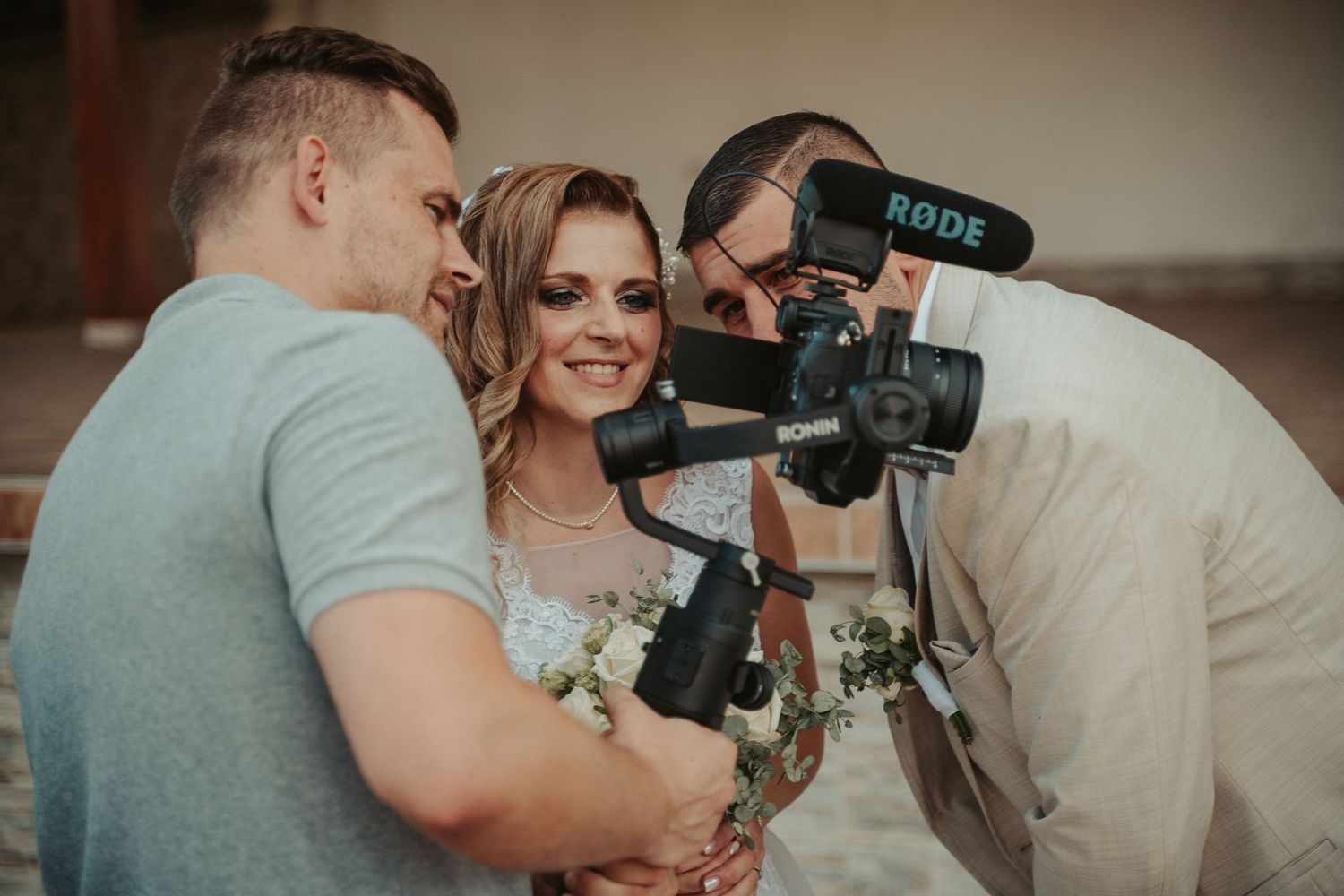 Wedding videographer records footage of a happy moment with professional camera and stabilizing equipment.