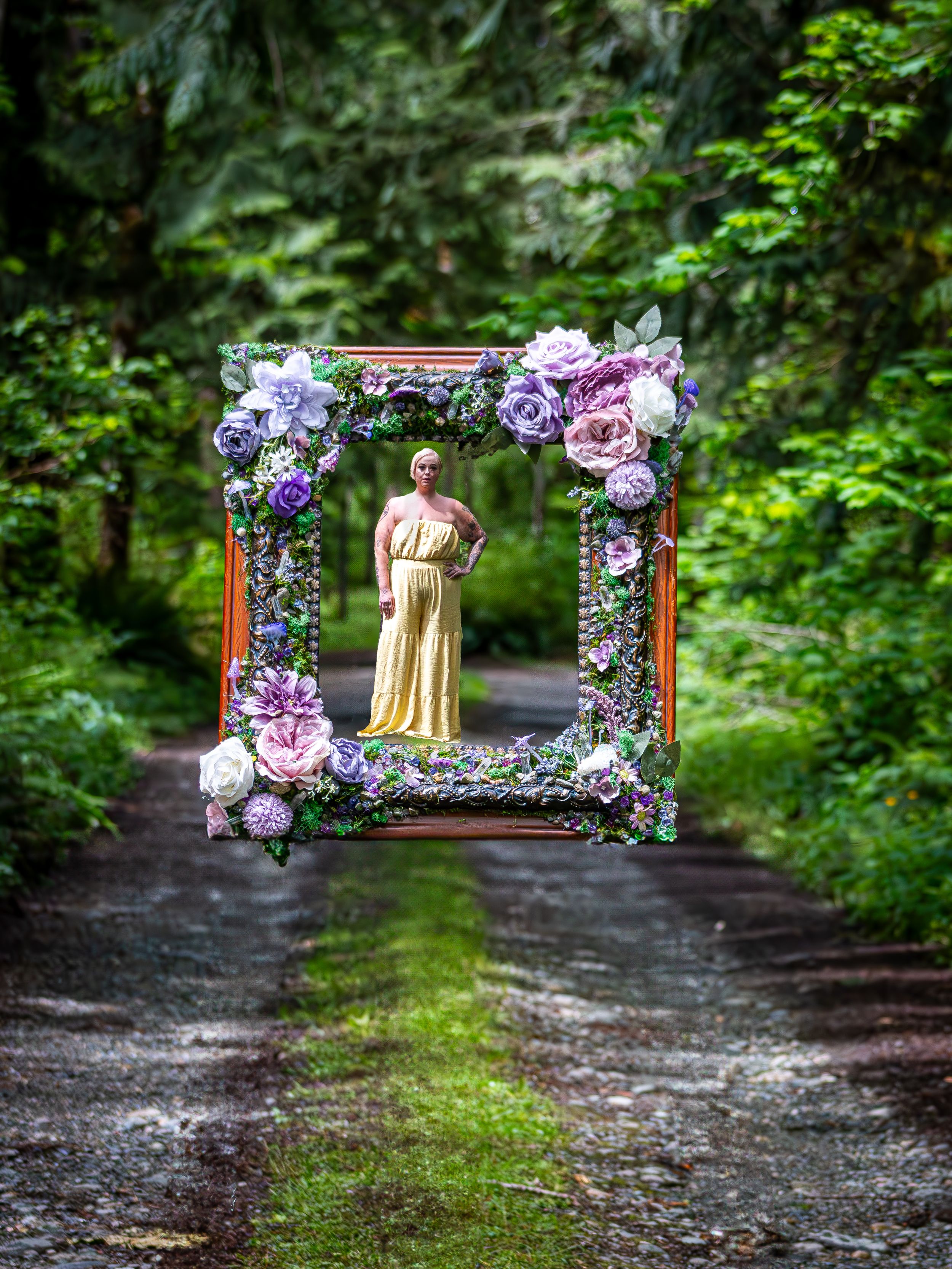 Decorative floral frame with purple and pink roses creates a romantic archway on a forest path.
