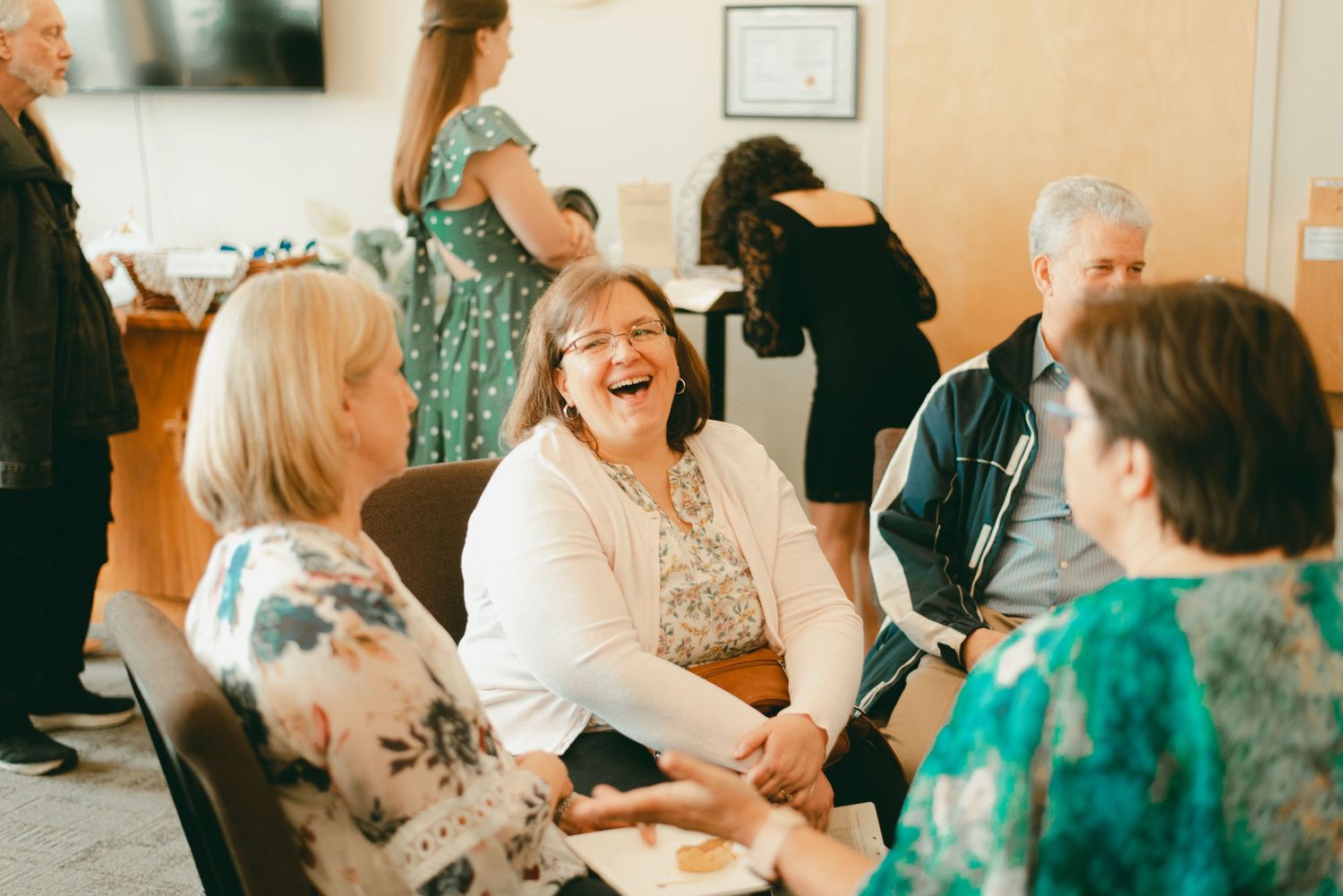 Family and friends laugh and talk together at lunchtime wedding reception