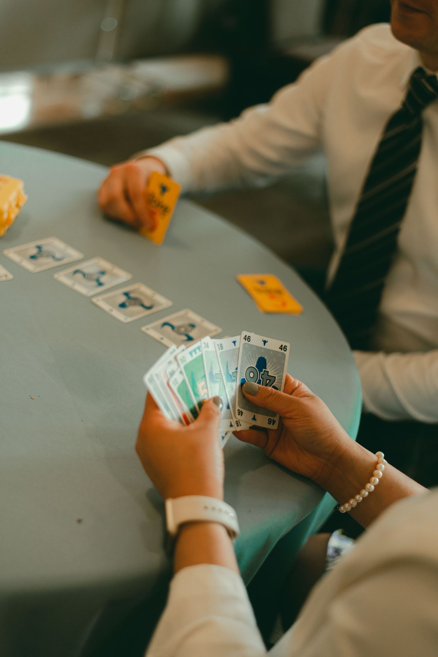Family and friends play card games together at lunchtime wedding reception