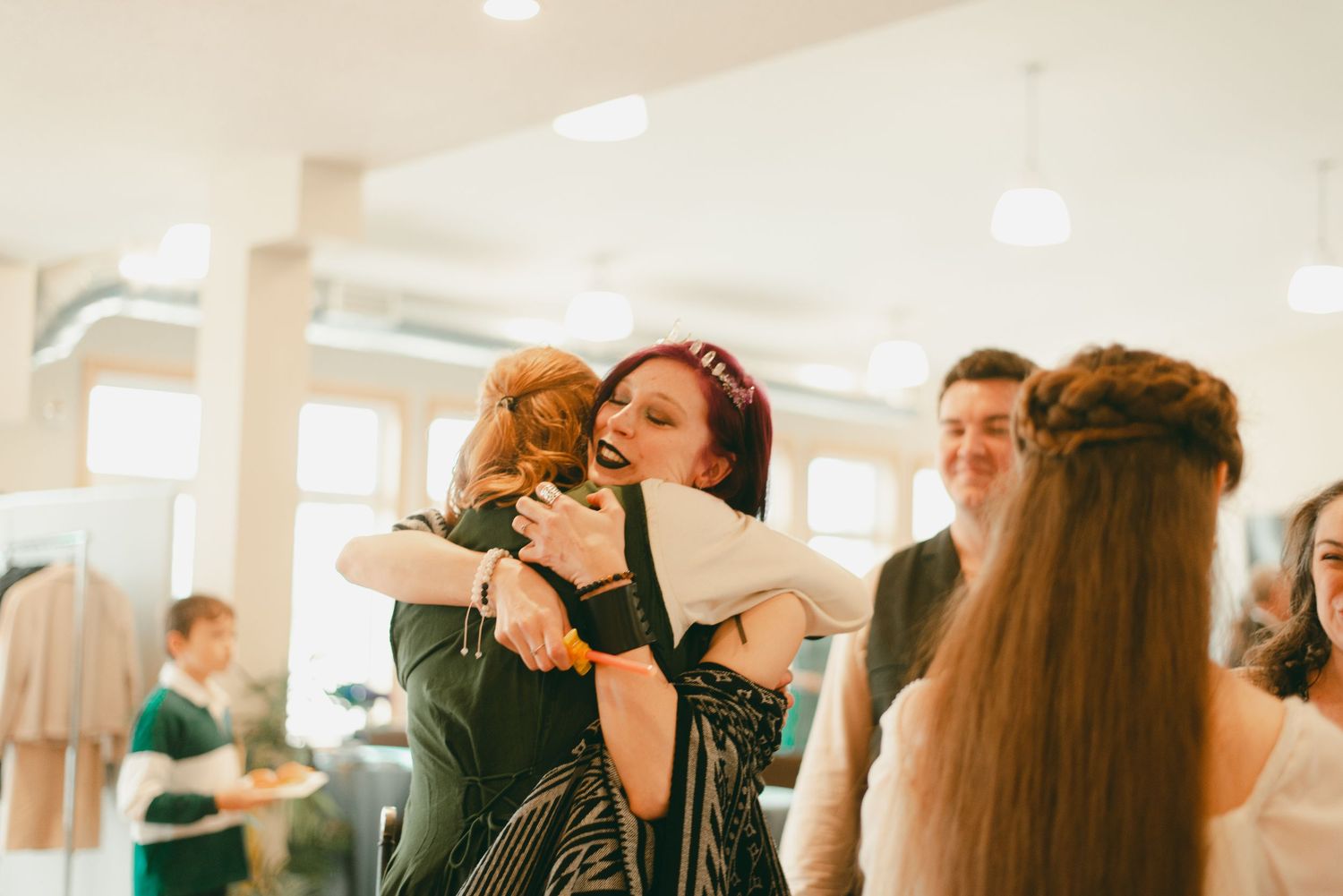Family and friends hug bride and groom at receiving line
