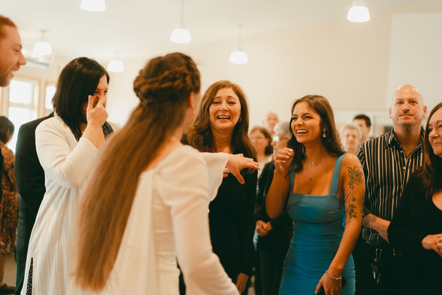 Family and friends hug bride and groom at receiving line