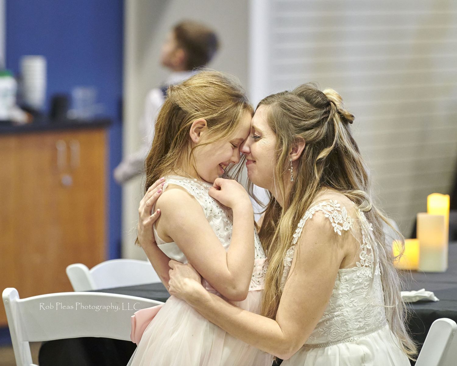 Bride hugging flower girl, who happens to be daughter