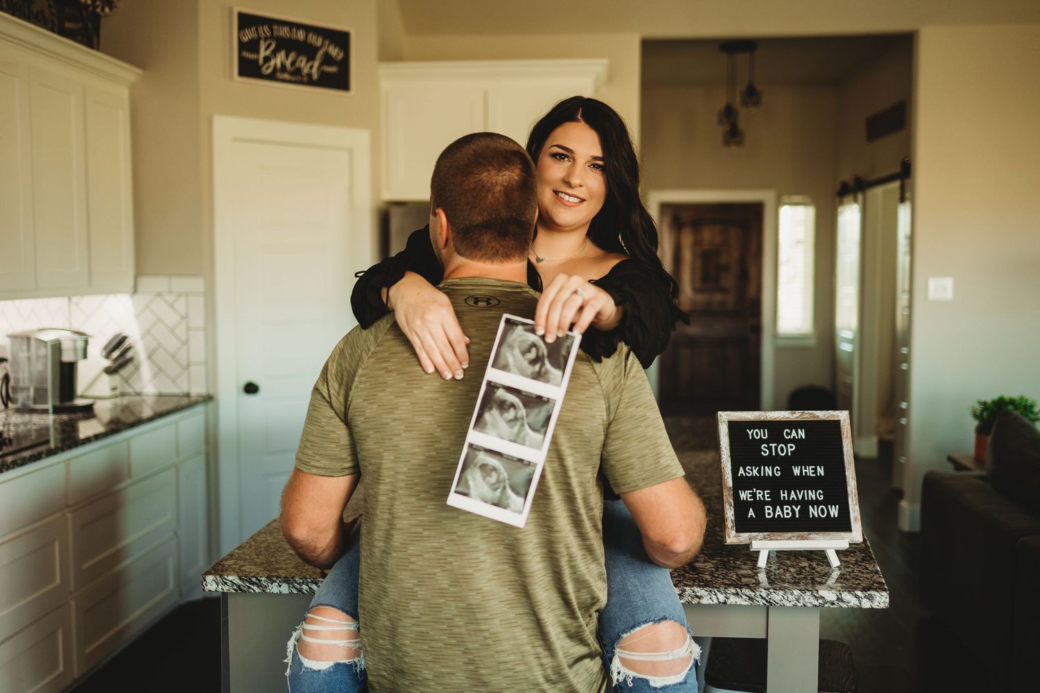 Husband and wife joyfully announce their baby on the way during a lifestyle photo session, captured by a professional family photographer.