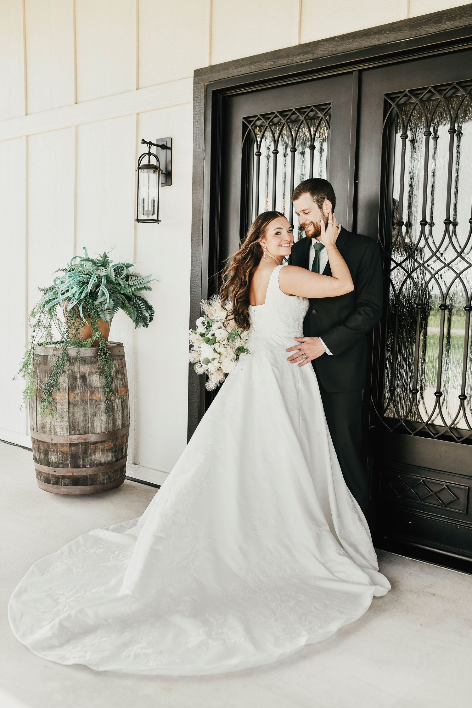 Elegant wedding couple in front of modern farmhouse-style venue