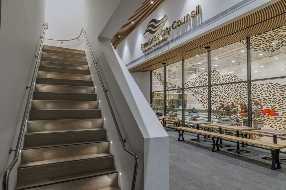 Staircase leading to a cafeteria area with and floor-to-ceiling windows. SIX84 Photography, Architectural Photography, Sydney