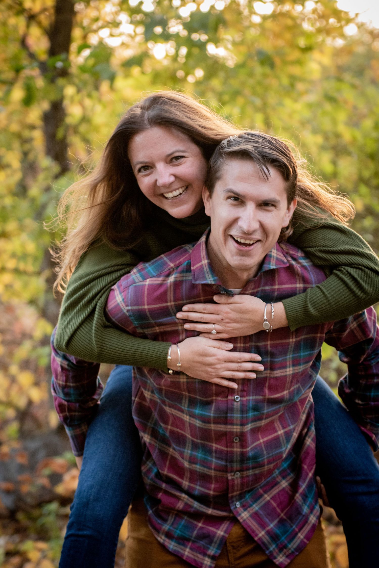 A playful piggyback ride moment captured during an autumn engagement photoshoot. Massachusetts Engagement Photographer Serving New England