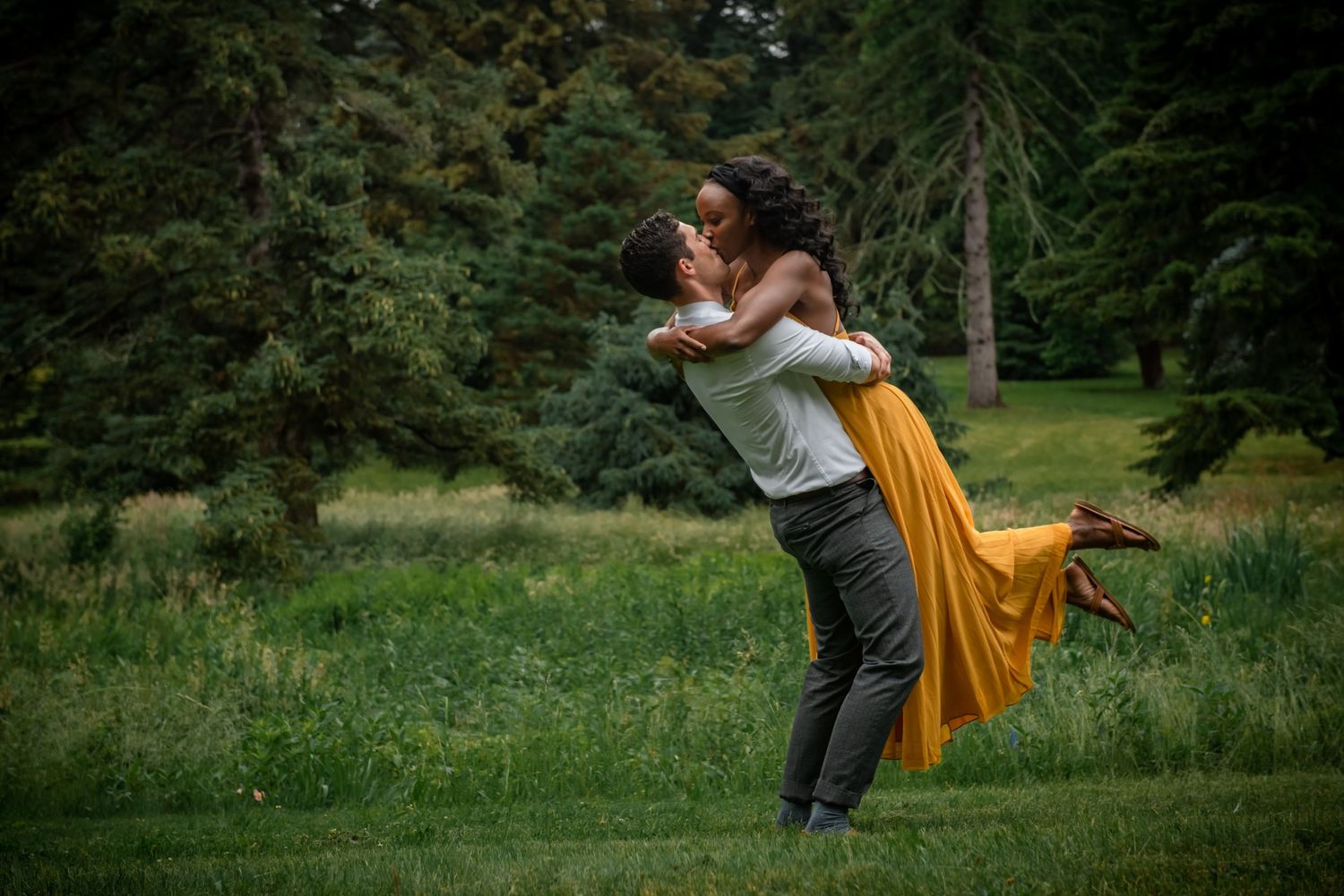 A romantic lift pose in a meadow with flowing yellow dress catching the breeze. Massachusetts Engagement Photographer- Affordable