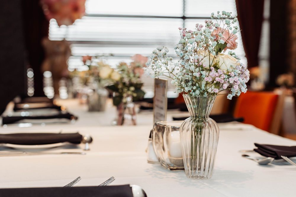 Elegant table setting with baby's breath flowers in clear glass vase at formal event.