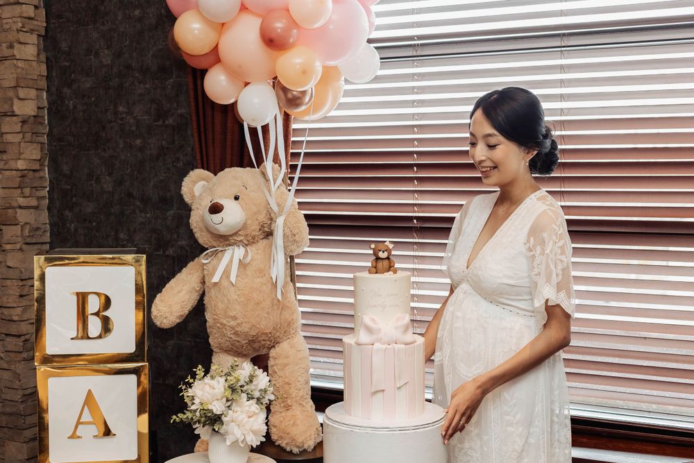 Baby shower celebration setup featuring balloons, teddy bear decorations and wooden letter blocks.