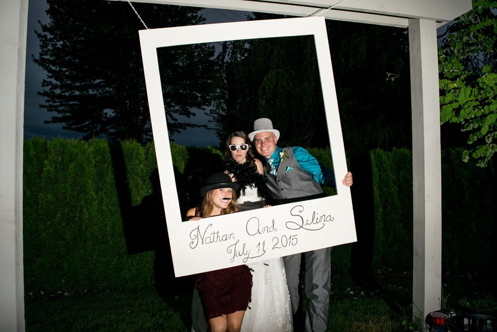 A fun photo booth moment captured in an oversized polaroid frame during an outdoor evening event.