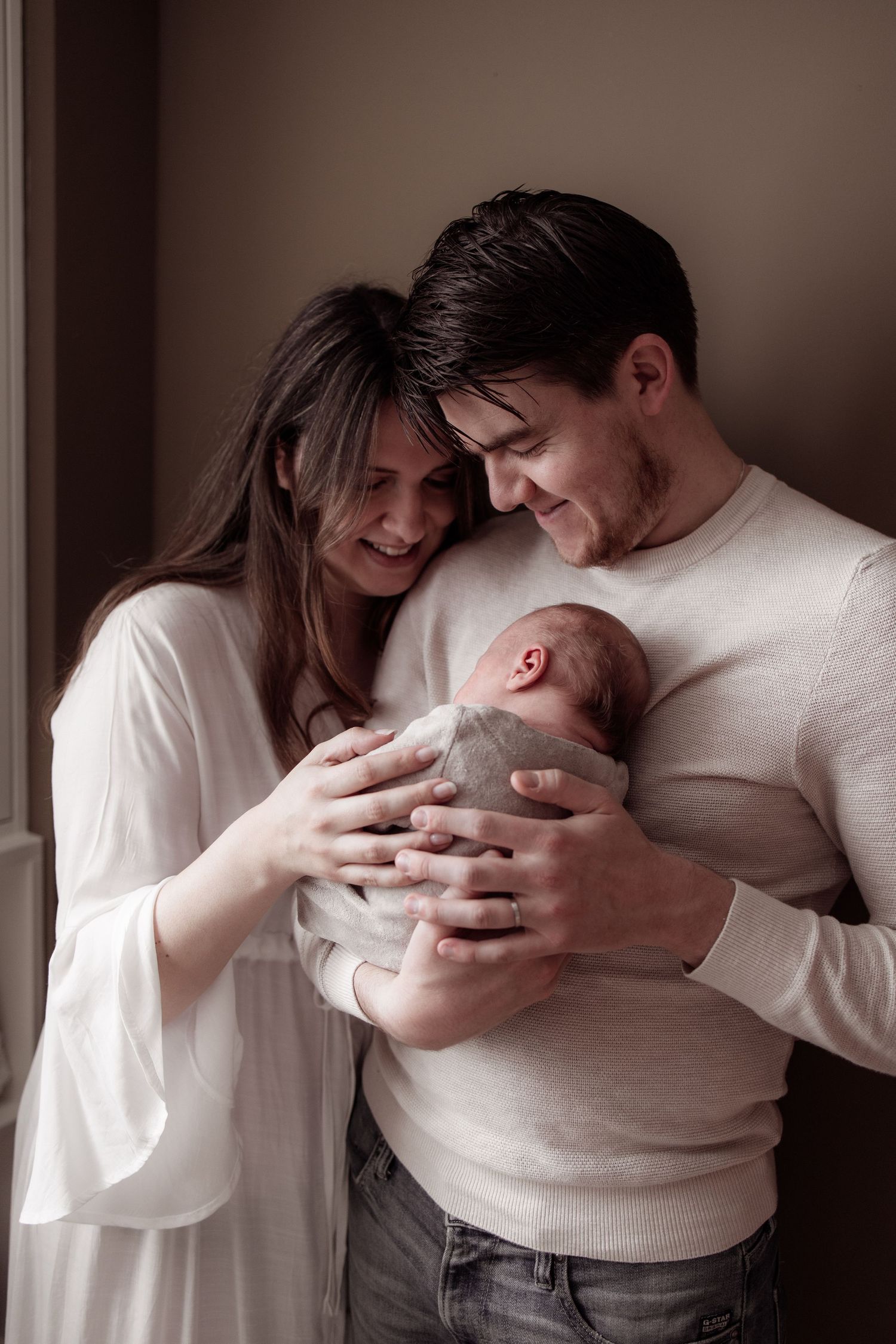 Gezinsfoto met newborn in warme en ontspannen setting