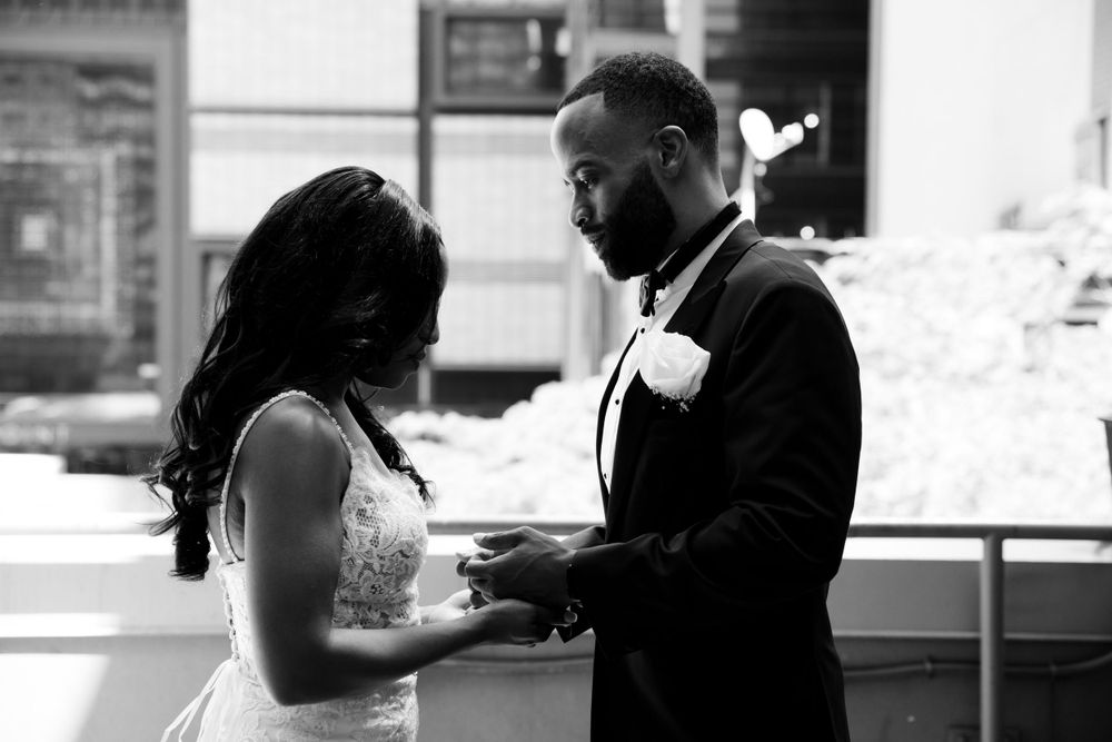 An intimate black and white moment of a couple exchanging vows during their wedding ceremony.