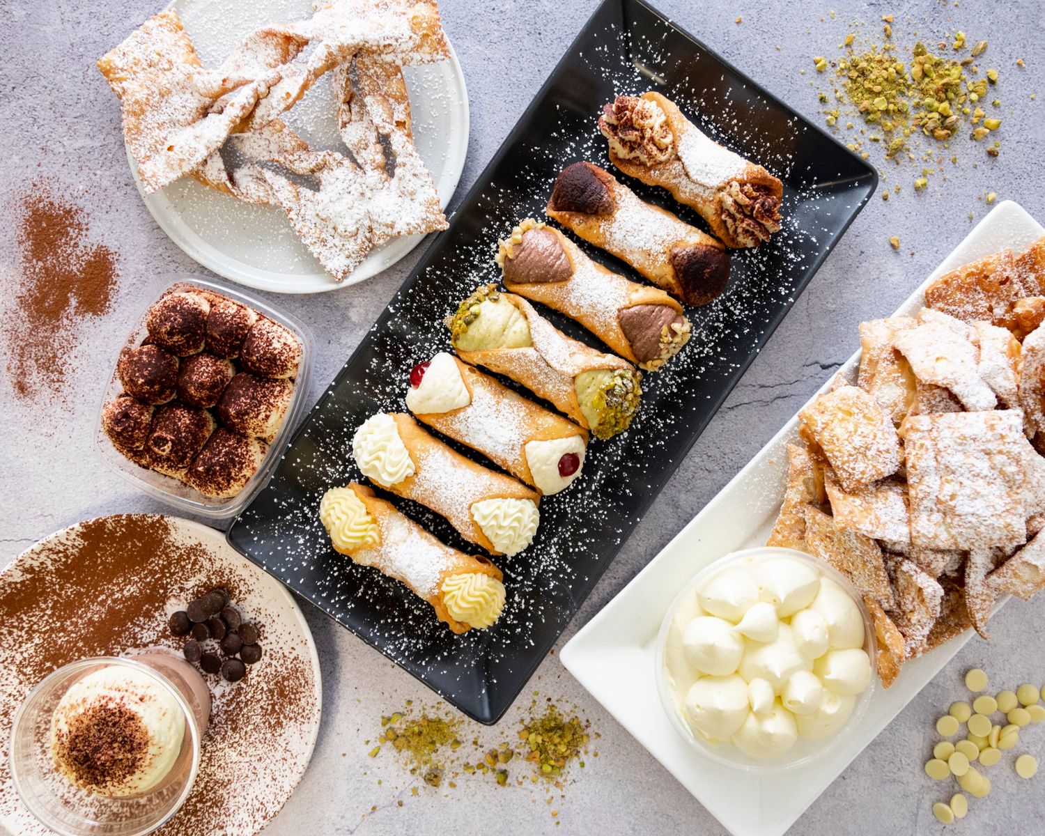 Assorted desserts including rolled pastries and powdered treats on modern serving plates.