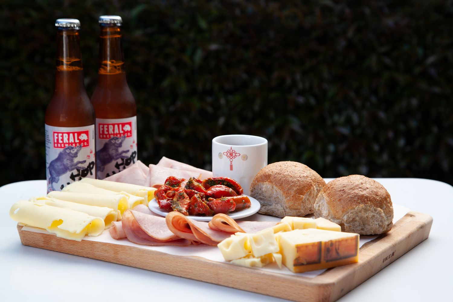 Charcuterie board with meats, cheese, and bread served alongside bottled drinks.