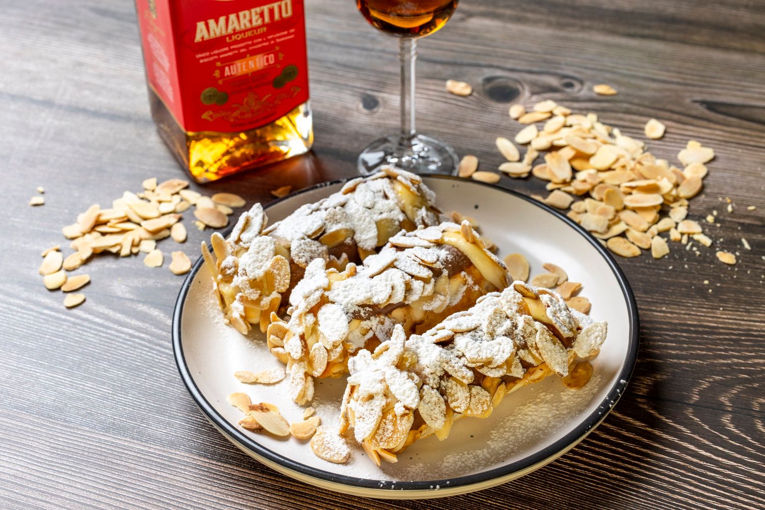 Dessert topped with sliced almonds and cream sauce served with Amaretto liqueur.
