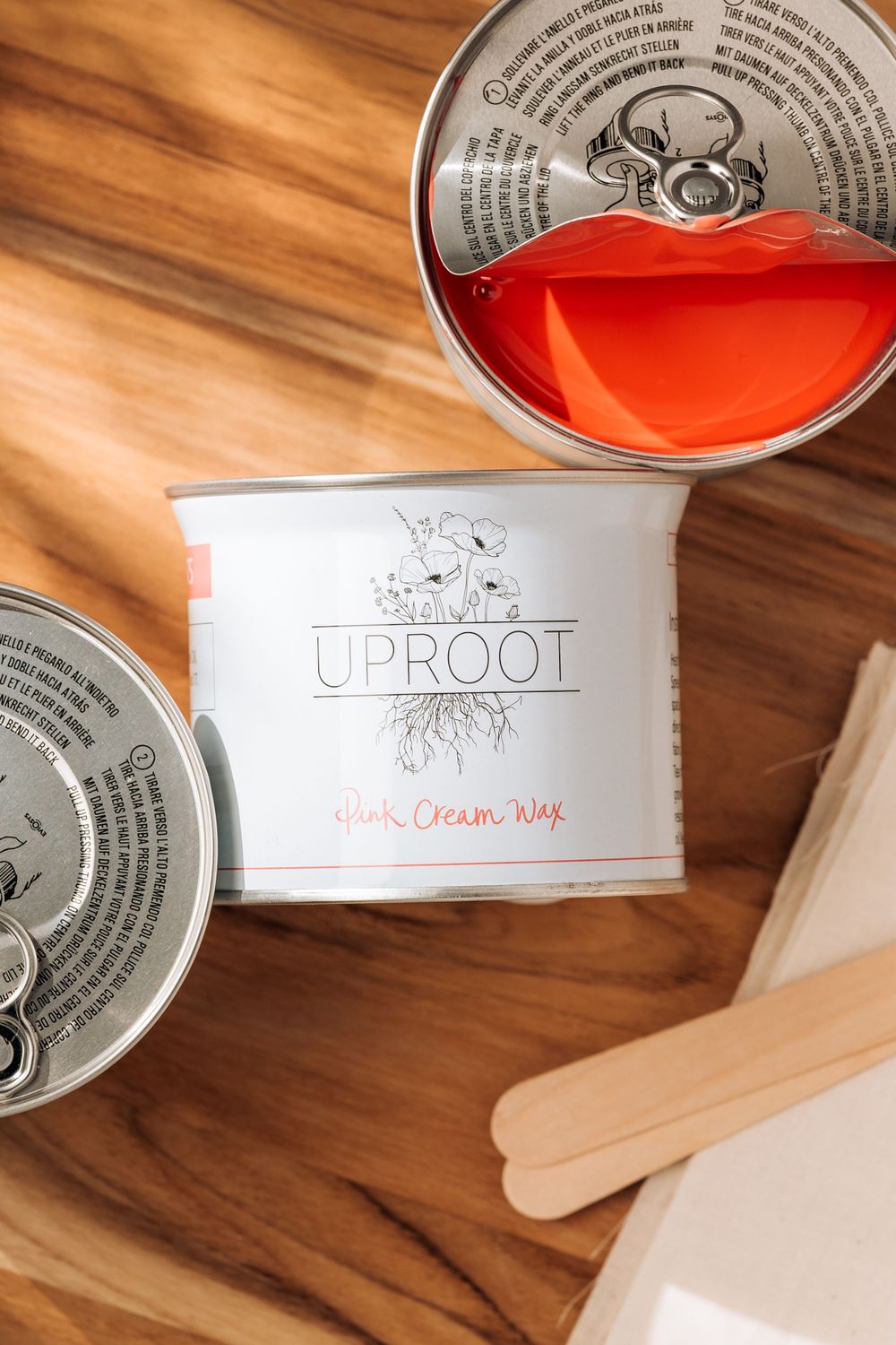 White paint can labeled 'UPROOT' with orange contents on wooden surface.