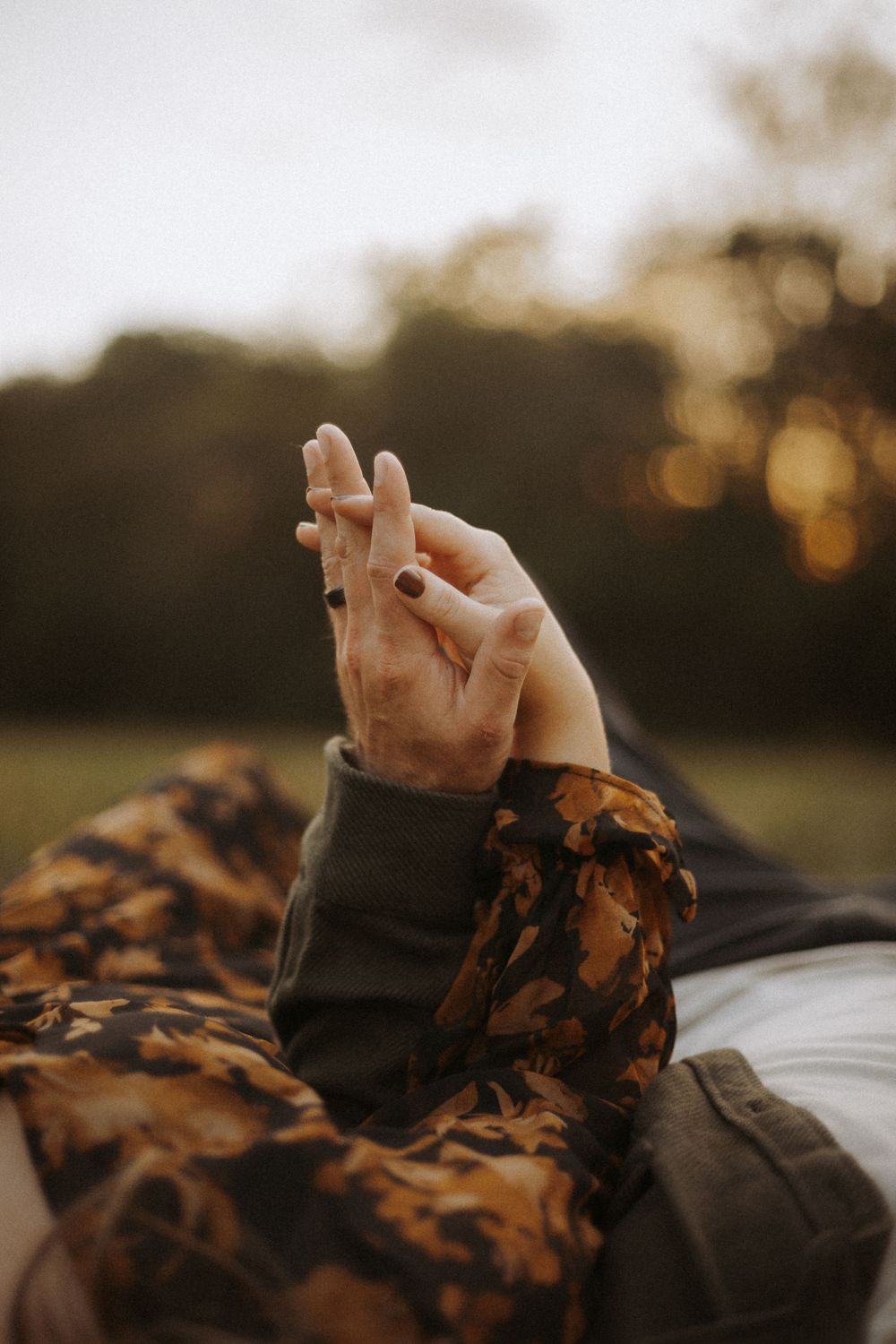 Close up of hands against sunset bokeh background.