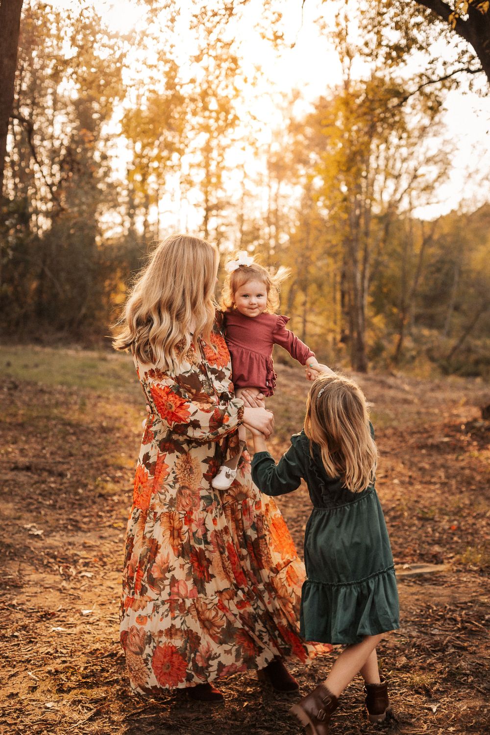 A heartwarming autumn scene shows a family embracing in a forest with warm golden sunlight filtering through trees.