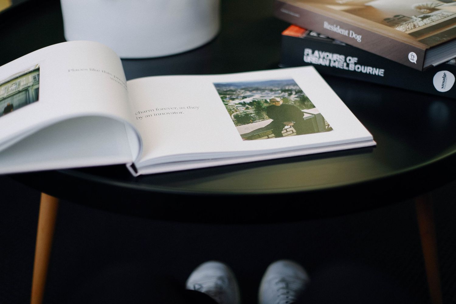 Open book displaying aerial photography on black coffee table.