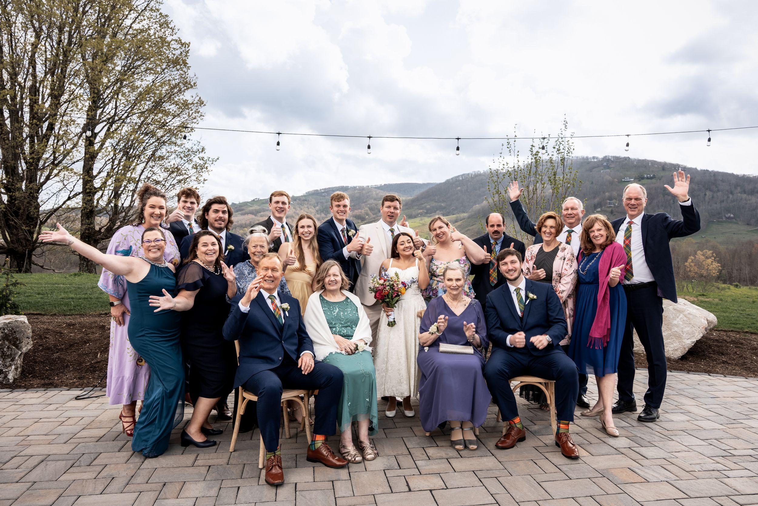 A sequence of group photos from various angles at a wedding event on an outdoor patio with mountains in the background.