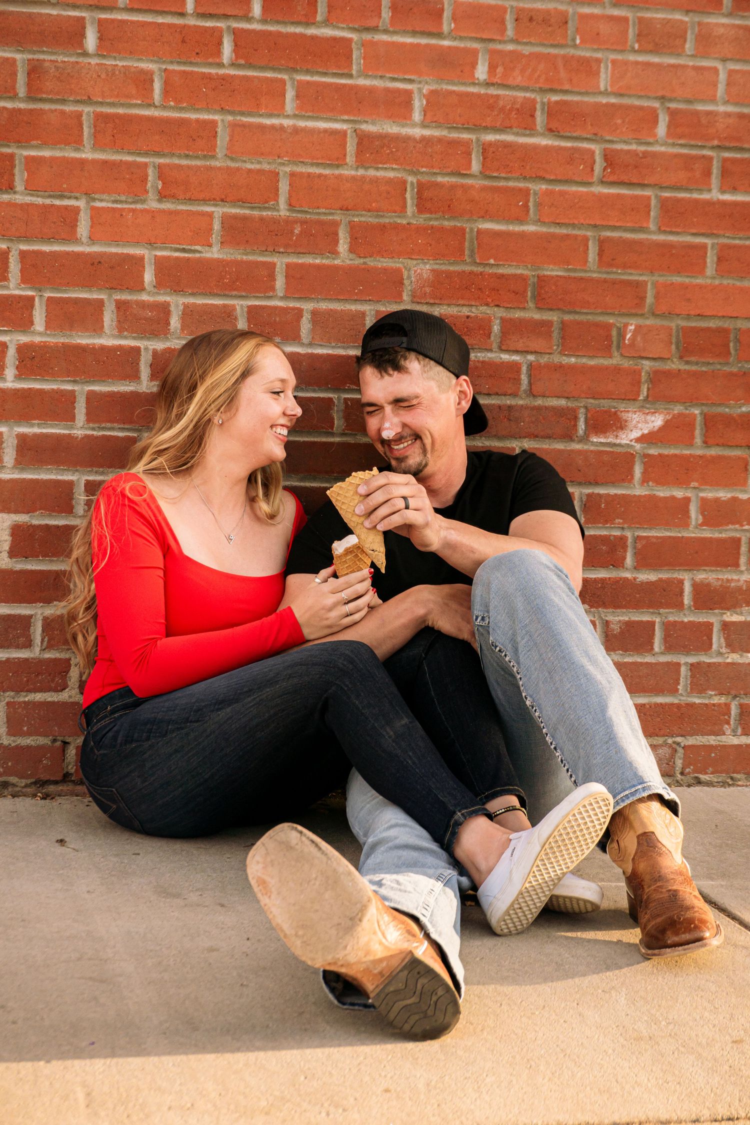 Colorado Springs Engagement Photographer. Couple sitting outside and eating ice cream on the ground during golden hour.