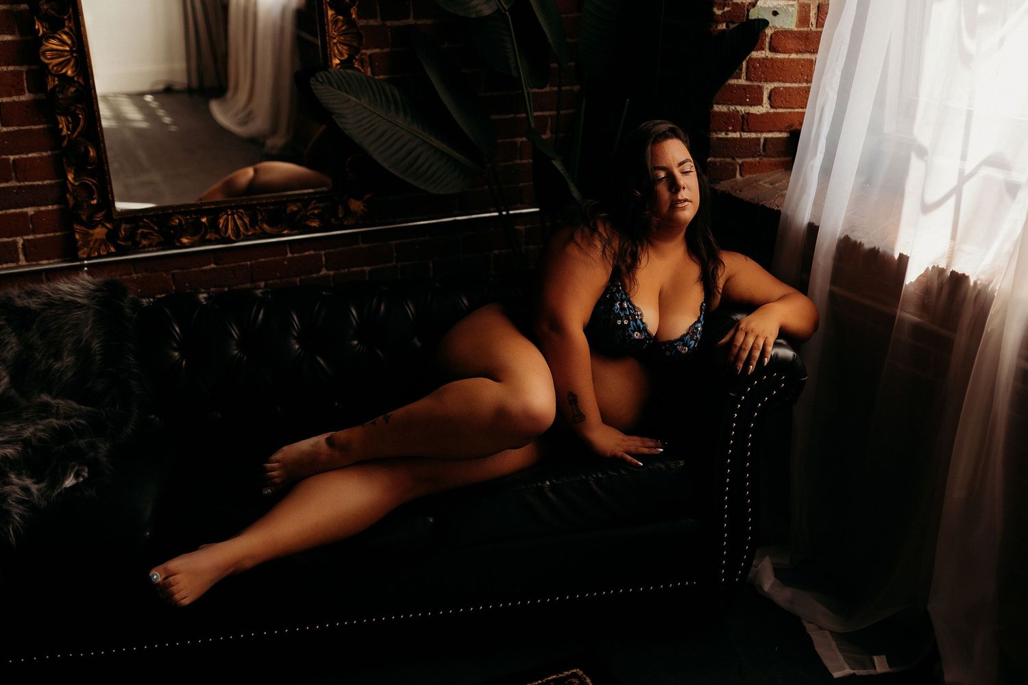 Sensual boudoir portrait on vintage leather chaise lounge.