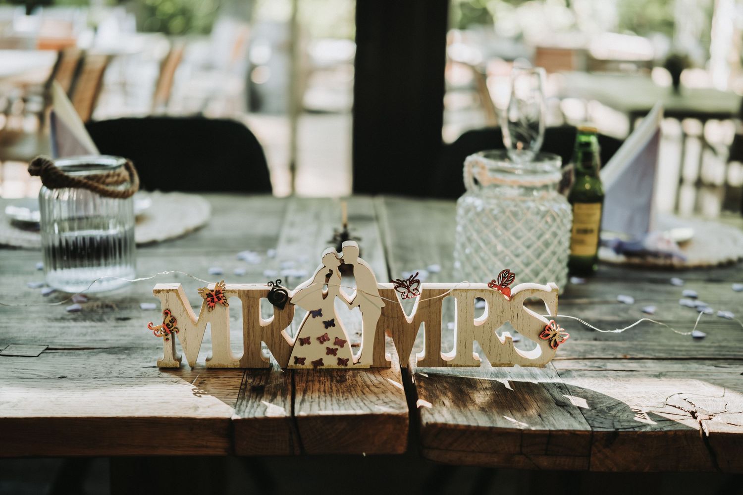 Wedding reception table setting with decorative Mr & Mrs sign centerpiece.