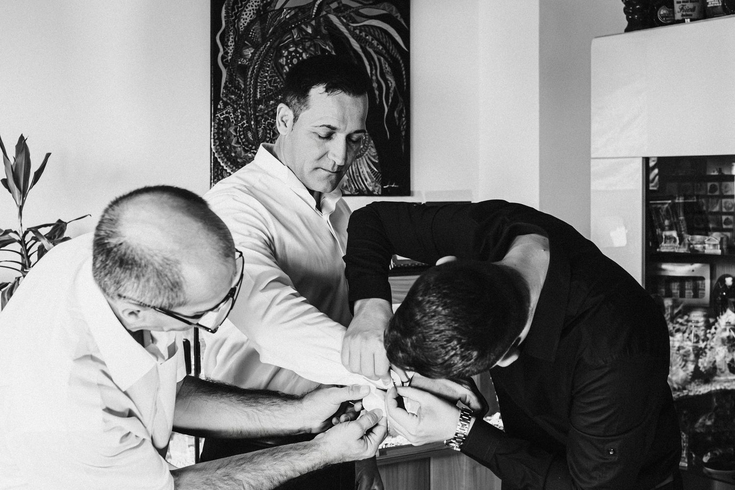 Wedding preparation scene showing final adjustments being made to formal attire.