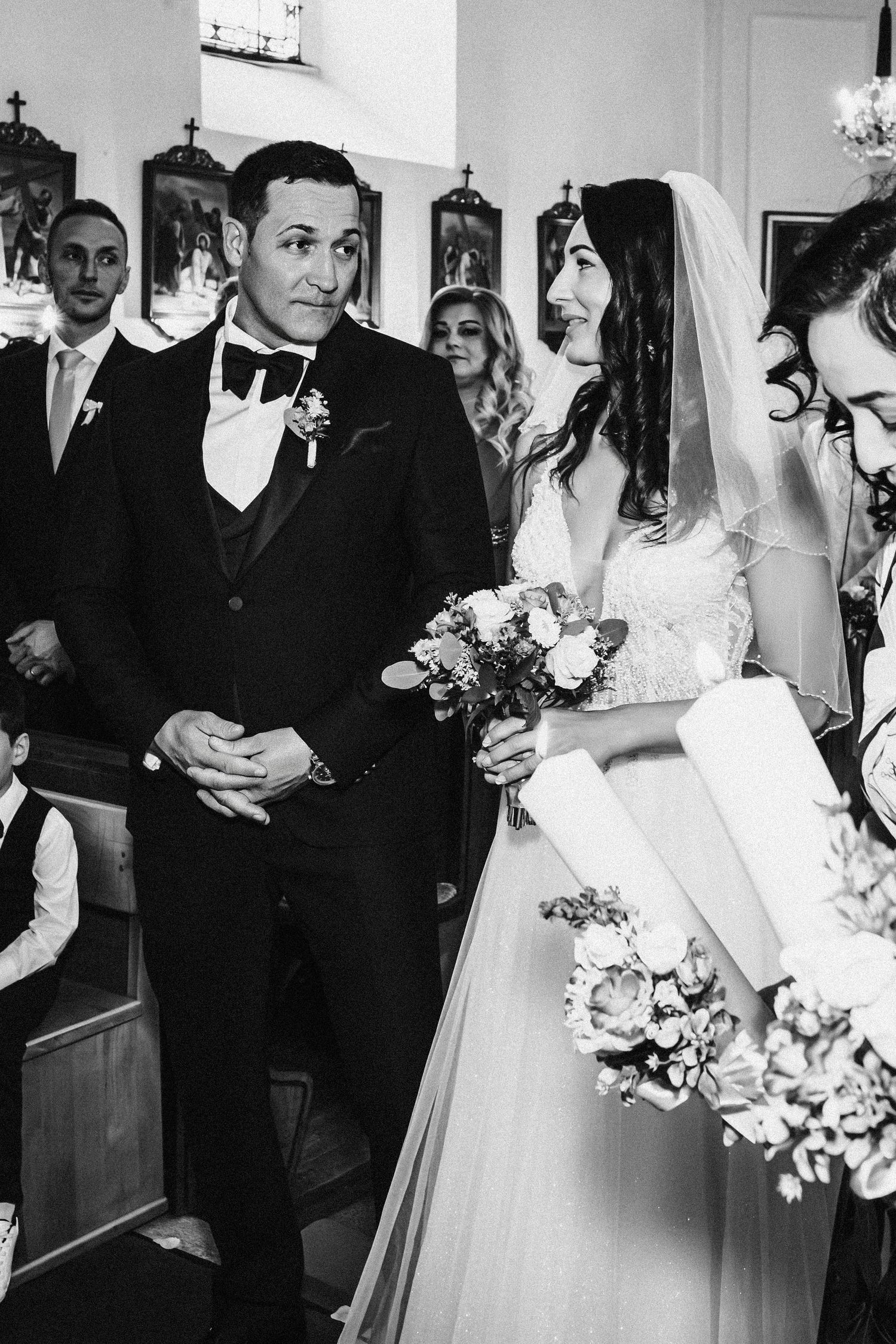 Black and white photo of a traditional church wedding ceremony with attendants and decorative details.