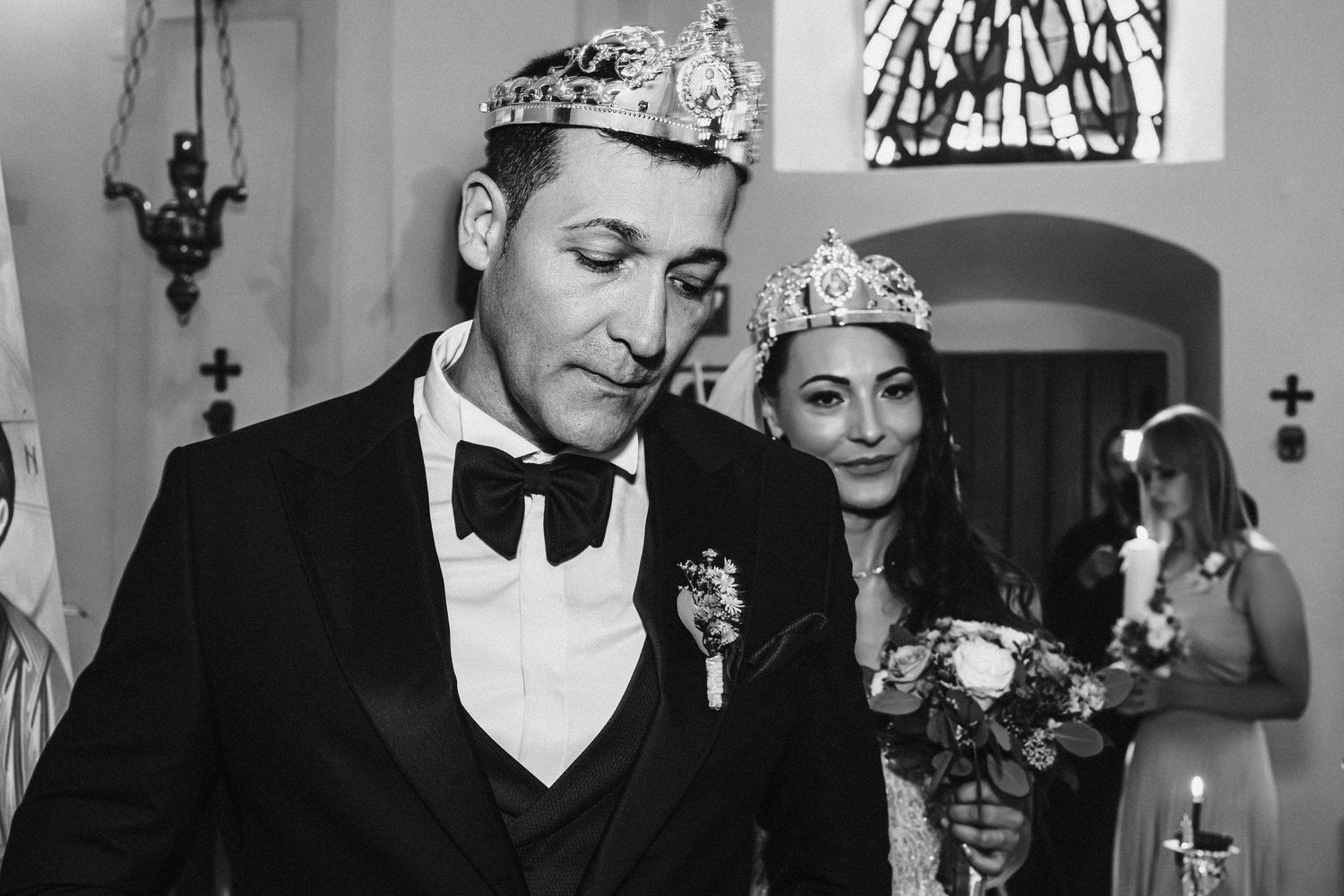 Couple wearing ceremonial crowns during traditional Orthodox wedding service.
