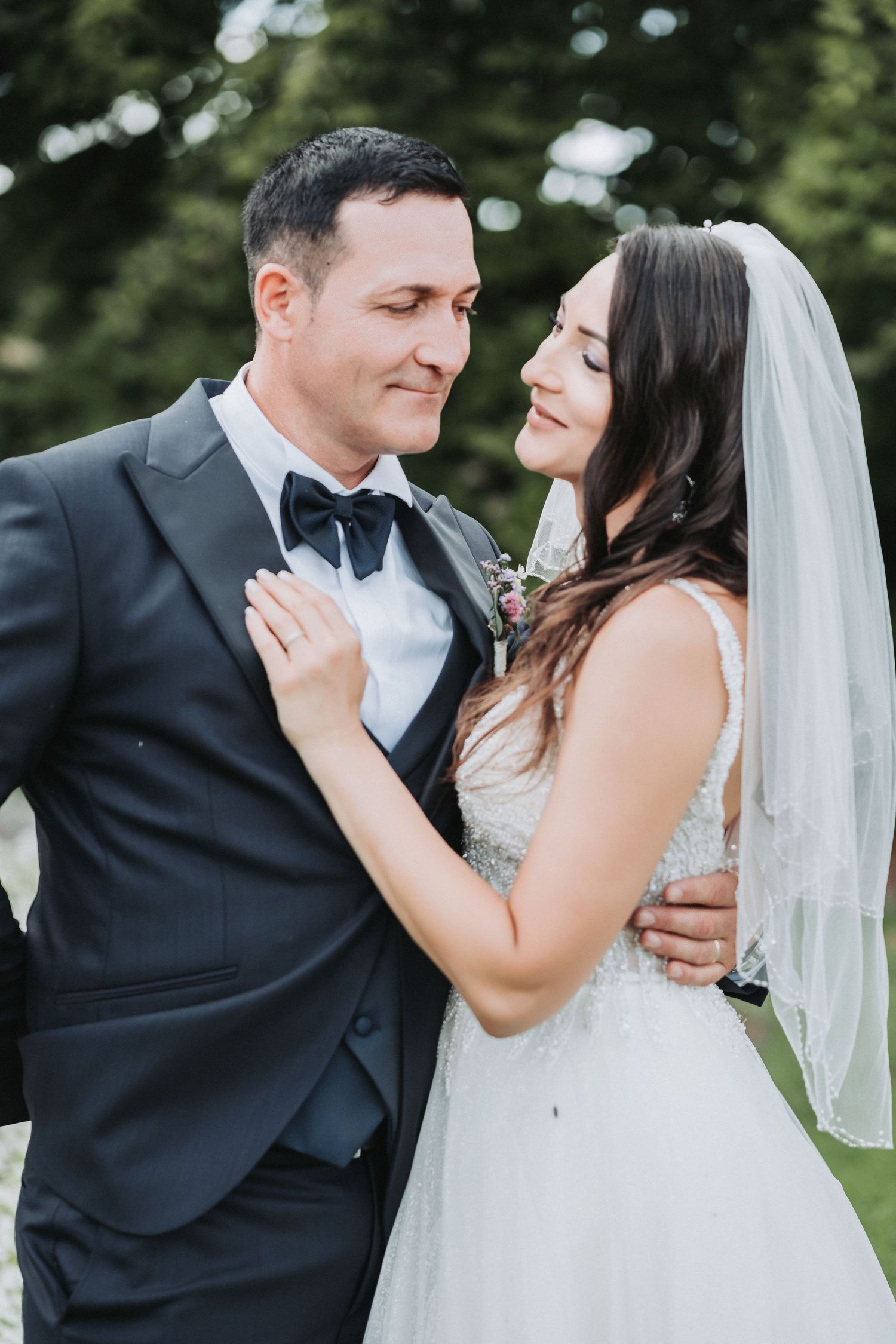 Intimate moment between newlyweds during outdoor wedding photo session.