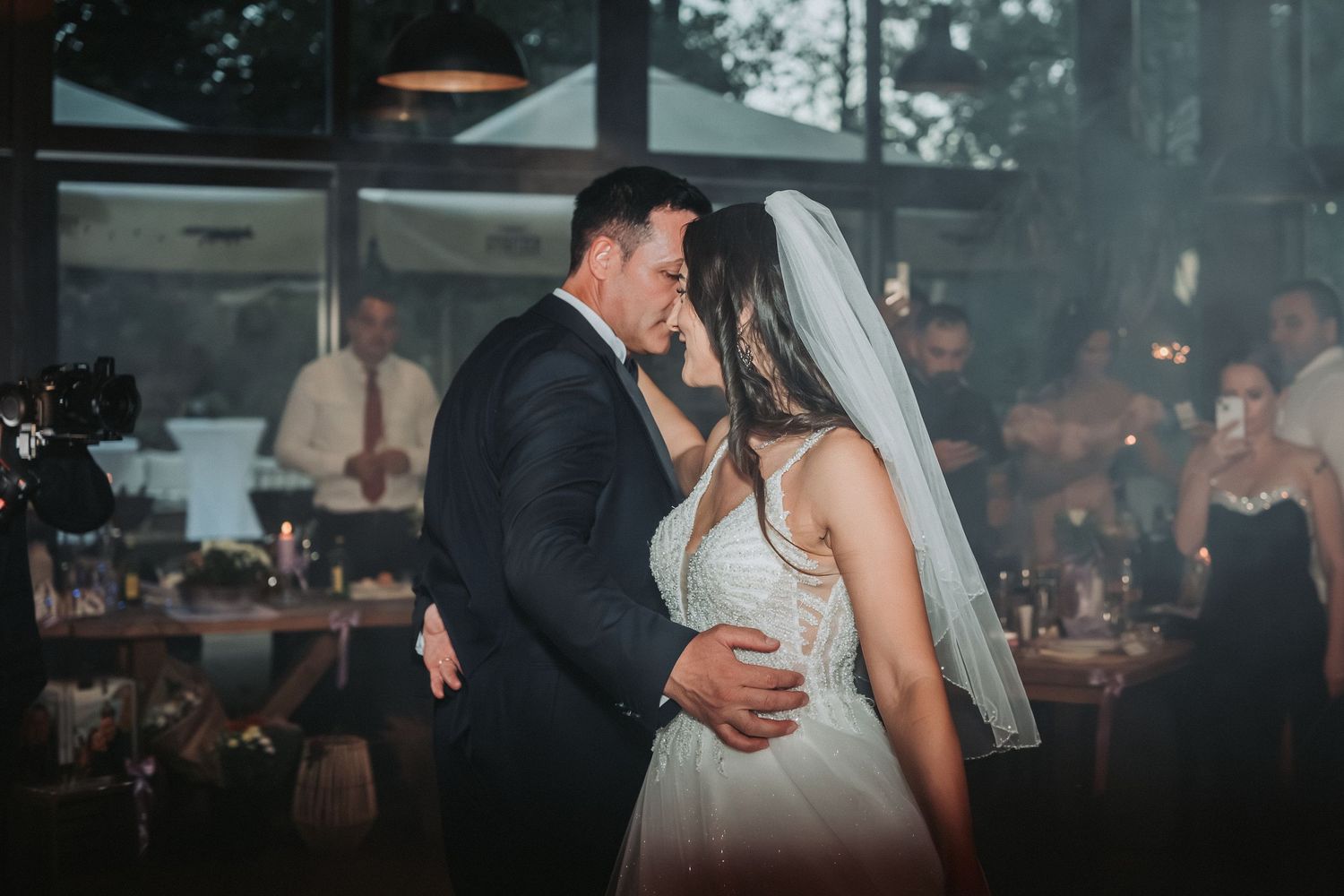 A romantic moment between newlyweds during their indoor reception celebration.