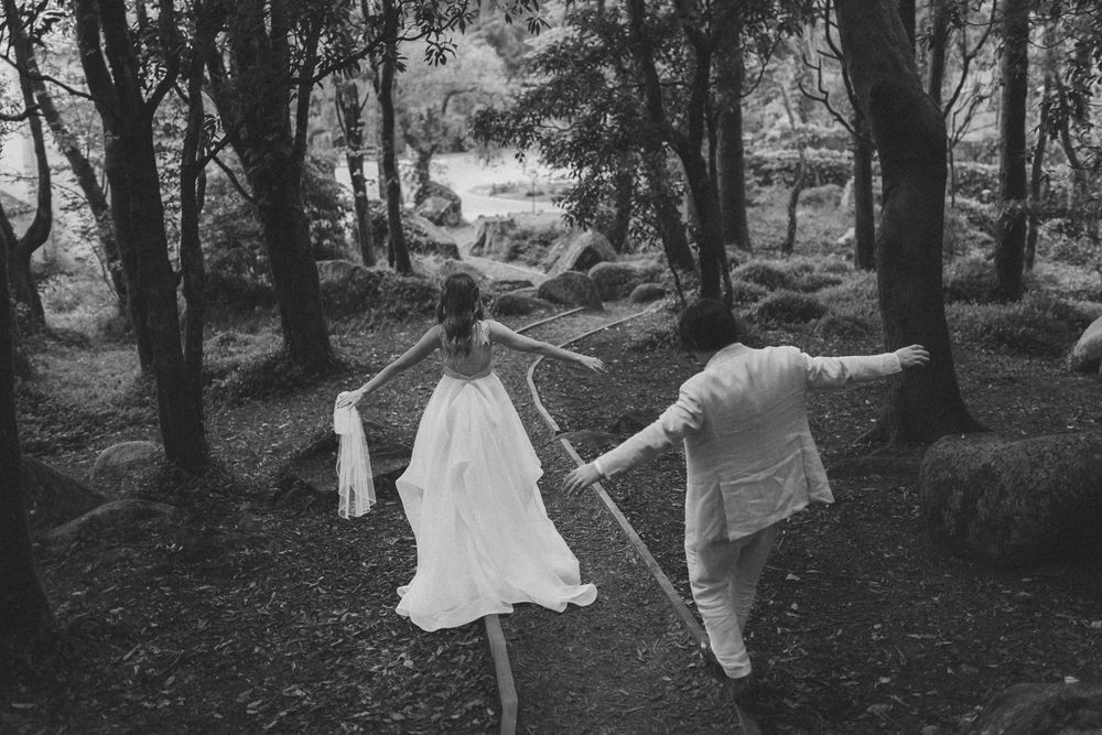 bride and groom running through a forest holding hands in Sintra. captured by a Portugal wedding photographer