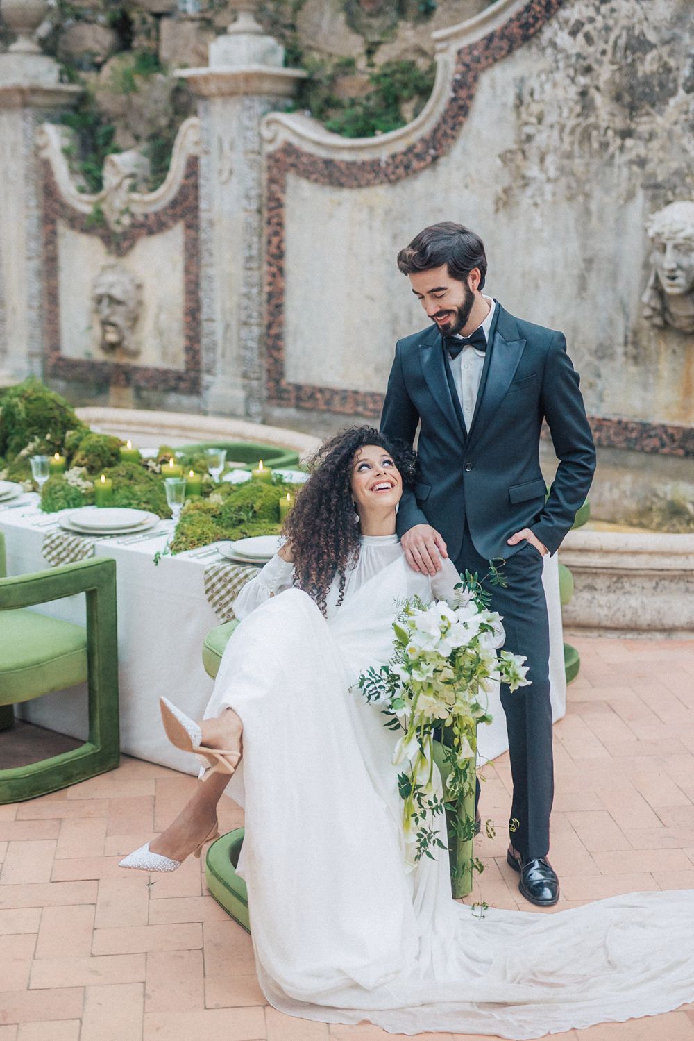 Bride & groom with beautiful floral arrangements at Casa dos Penedos, Sintra, Portugal. A moment captured by a Portugal wedding photographer