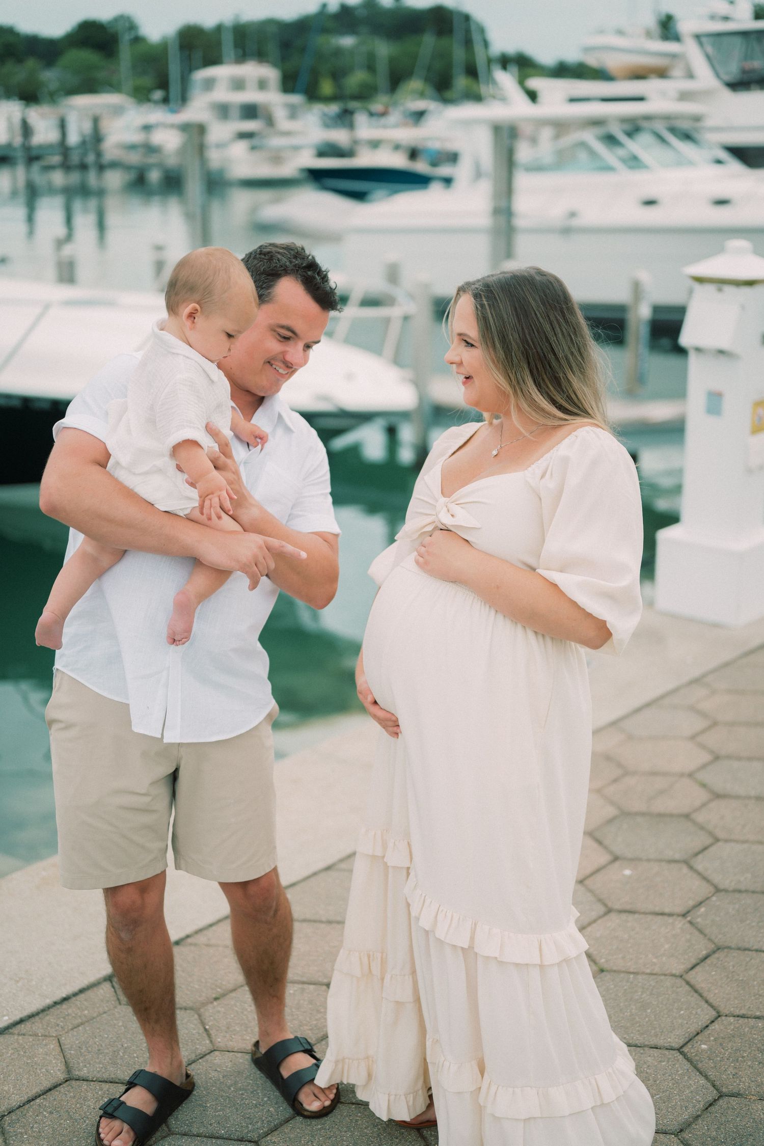 A family moment at a marina with boats in the background.