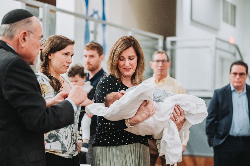 Yoav's grandmother holds him after his Bris at Ohev Shalom in Washington, DC.