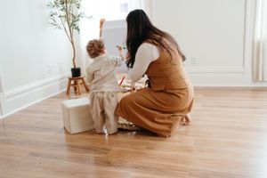 Parent and child drawing together at an easel in a modern minimalist room.