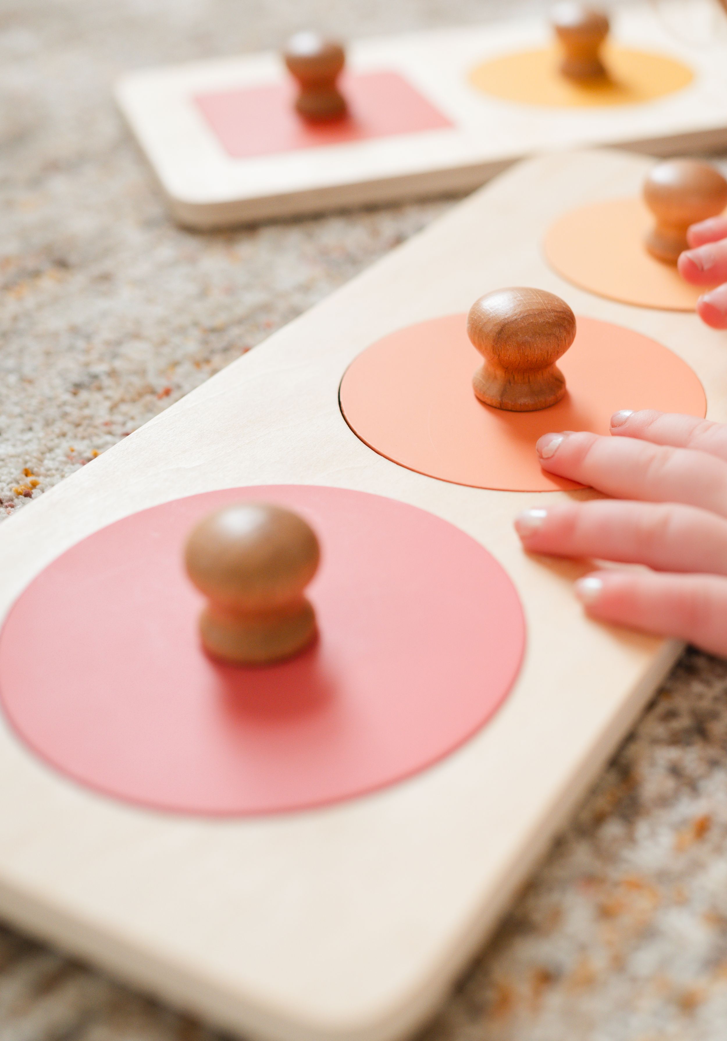 Close-up of wooden knobs on pink circular discs mounted on a white wooden board.