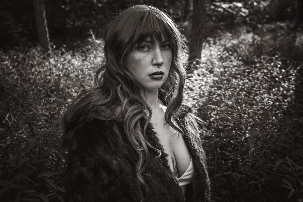 Dramatic black and white portrait set against wild flowering meadow.