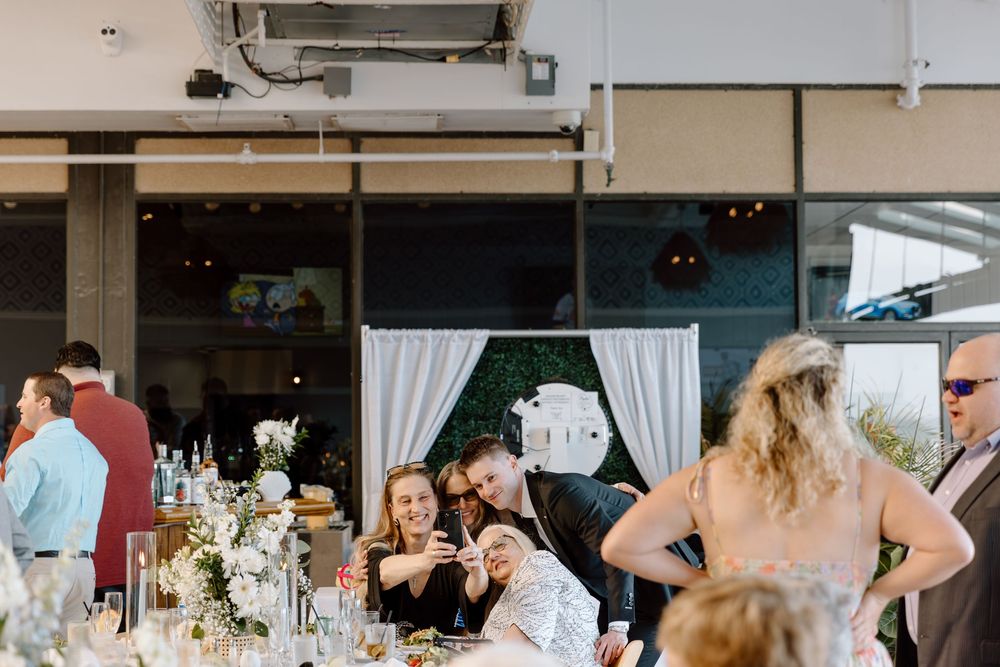 Wedding reception dining area with white table settings and rustic industrial decor elements.