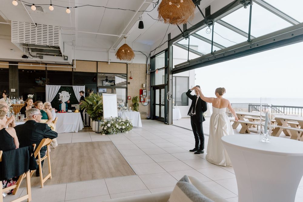Wedding celebration in a modern venue with large windows overlooking a scenic view.