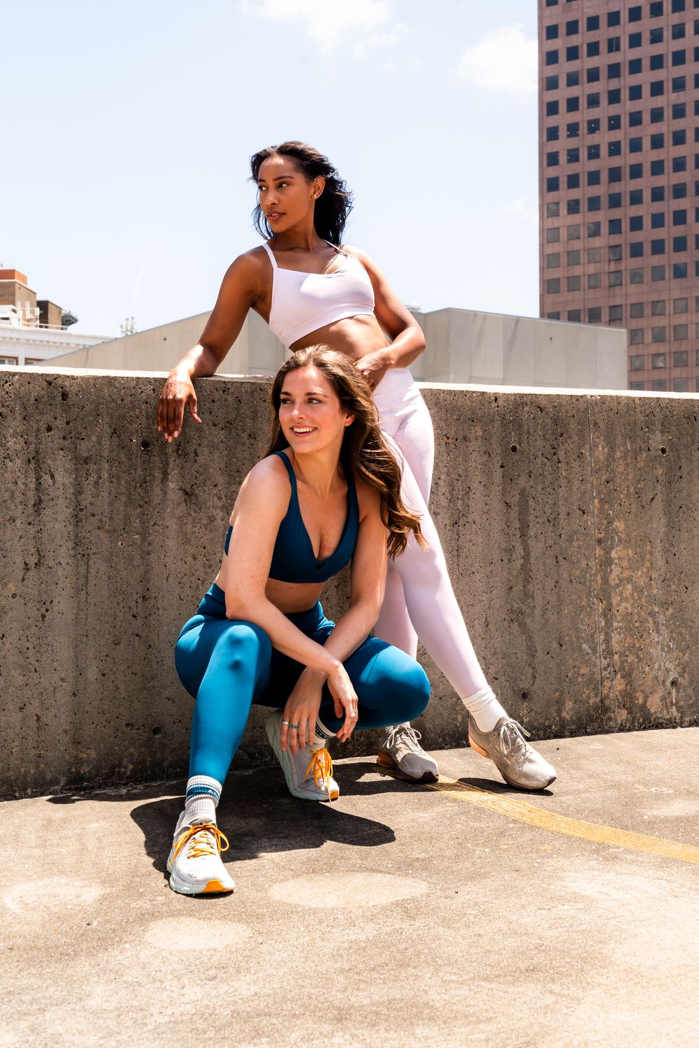 Athletic women taking a break during their rooftop workout session in the city.