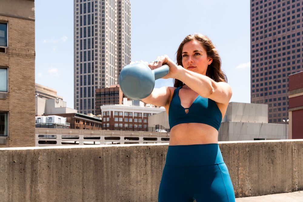Skyline view of urban buildings with women exercising on rooftop.