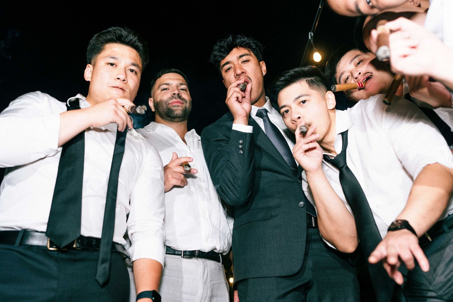 Group photo showing wedding party members making silly expressions and poses in formal attire.