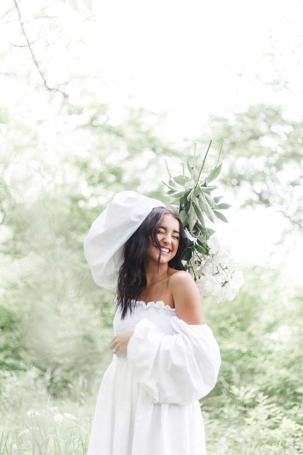An elegant white wedding dress with puffy sleeves flows in a dreamy outdoor garden setting with soft natural lighting.